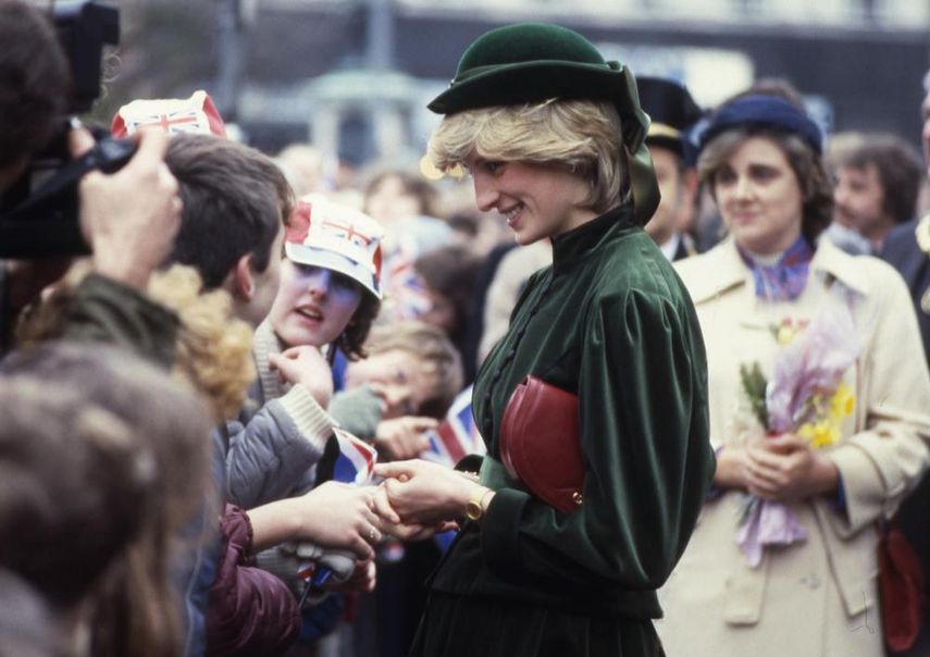 Diana, la princesa de Gales, saluda de mano y charla con niños de primaria durante una visita a un nuevo centro comercial en Aylesbury, Bucks, Inglaterra el 2 de marzo de 1983. La muerte de Diana sorprendió al mundo, y cambió a la familia real. La mujer, que pasó de ser una tímida adolescente y maestra de jardín de infantes a una glamurosa celebridad que reconfortaba a pacientes con sida y hacía campaña para remover minas terrestres, había muerto a los 36 años.&nbsp;