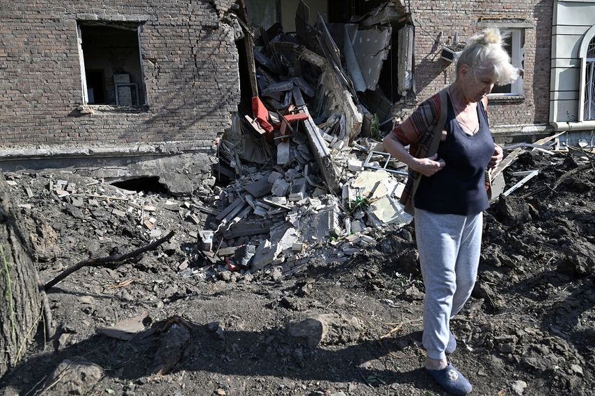 Un residente local camina frente a un cráter de un misil alcanzado frente a un edificio residencial parcialmente destruido en la ciudad ucraniana de Bakhmut, el 1 de julio de 2022, en medio de la invasión militar de Rusia lanzada contra Ucrania.