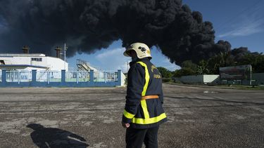 Un bombero se encuentra cerca de un tanque de petróleo en llamas en Matanzas, Cuba, el 6 de agosto de 2022.&nbsp;