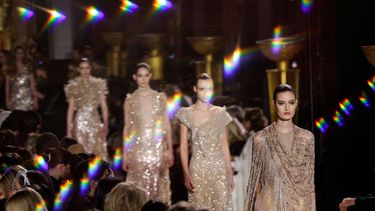 Fotografía tomada a través de un cristal que muestra a modelos presentando creaciones de Elie Saab para el desfile de la colección de alta costura primavera/verano 2026, en el marco de la Semana de la Moda de Alta Costura de París, en París, el 28 de enero de 2026.