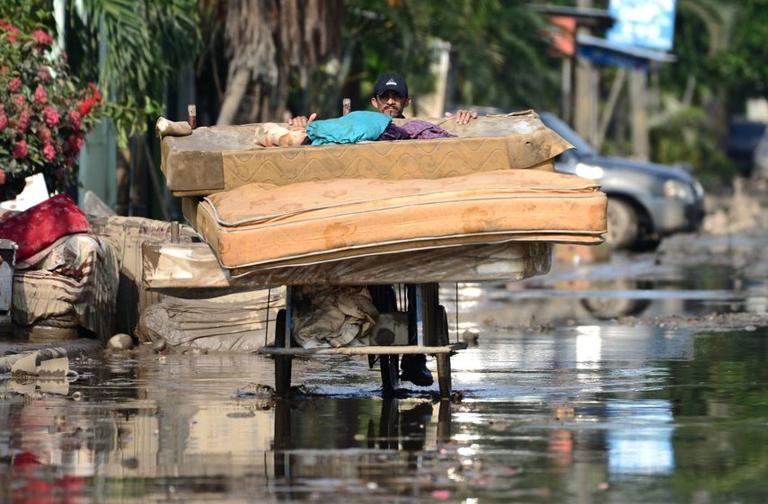 Un hombre rescata un colchón después del paso del huracán Eta, ahora degradado a tormenta tropical, en Planeta, municipio de La Lima, en el departamento hondureño de Cortés, el 9 de noviembre de 2020. La tormenta tropical Eta tocó tierra en los Cayos de Florida el domingo por la noche. trayendo fuertes lluvias y fuertes vientos después de azotar a Cuba y antes de abrir un camino mortal a través de Centroamérica y el sur de México. Al menos 200 personas están muertas o desaparecidas después de que Eta, inicialmente clasificado como huracán, arrasó Nicaragua, Guatemala y Honduras, causando inundaciones y deslizamientos de tierra.