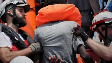 En esta foto tomada el 10 y distribuida el 11 de agosto de 2019, socorristas del buque Ocean Viking operado por las ONG Sos Mediterranee y Médicos Sin Fronteras ayudan a una persona rescatada junto con más de 80 de una embarcación precaria frente a la costa de Libia.