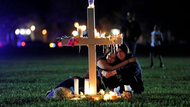 Dos personas se consuelan frente a una de 17 cruces colocadas en memoria de las personas fallecidas en un tiroteo en la Escuela Marjory Stoneman Douglas en Parkland, Florida, el 15 de febrero de 2018.&nbsp; &nbsp;