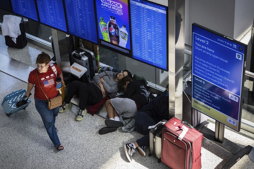 Viajeros con vuelos demorados duermen bajo unas pantallas en la Terminal C del Aeropuerto Internacional de Newark, Nueva Jersey, el miércoles 28 de junio de 2023.&nbsp;