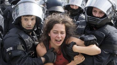 Una joven es arrestada durante los disturbios.