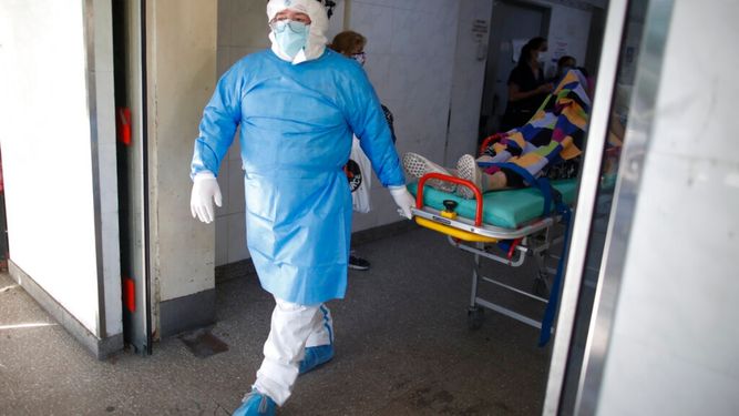 Un médico traslada a un paciente con COVID-19 a una ambulancia para ser transferido a otro hospital en Avellaneda, Argentina.&nbsp;