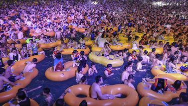 Esta foto tomada el 15 de agosto de 2020 muestra a personas que ven una actuación mientras se refrescan en una piscina en Wuhan, en la provincia central china de Hubei.