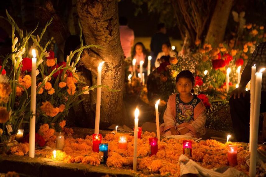 Habitantes ofrendan comida, bebidas y flores a sus muertos y los acompañan durante toda la noche hoy, domingo 1 de noviembre de 2015, en un cementerio de la comunidad Santa Maria Atzompa, en el estado de Oaxaca (México). (EFE)